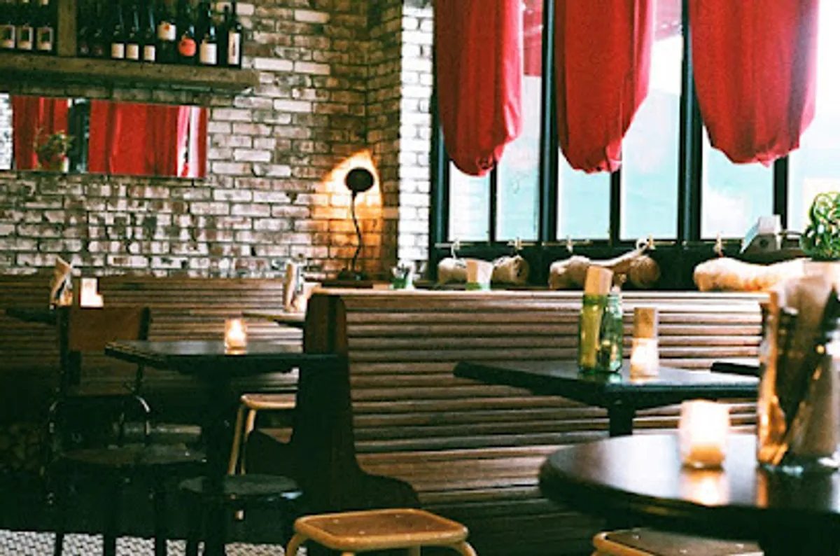 Interior view of Ops restaurant, showcasing their wood-fired pizza oven and dining setup.